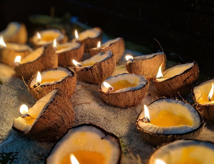 Rows of lit lamps in coconut shells